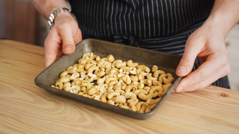 Cashews in a Tray, Ready for Roasting. Cashew Recipe. Benefits of Cashews in Nutrition